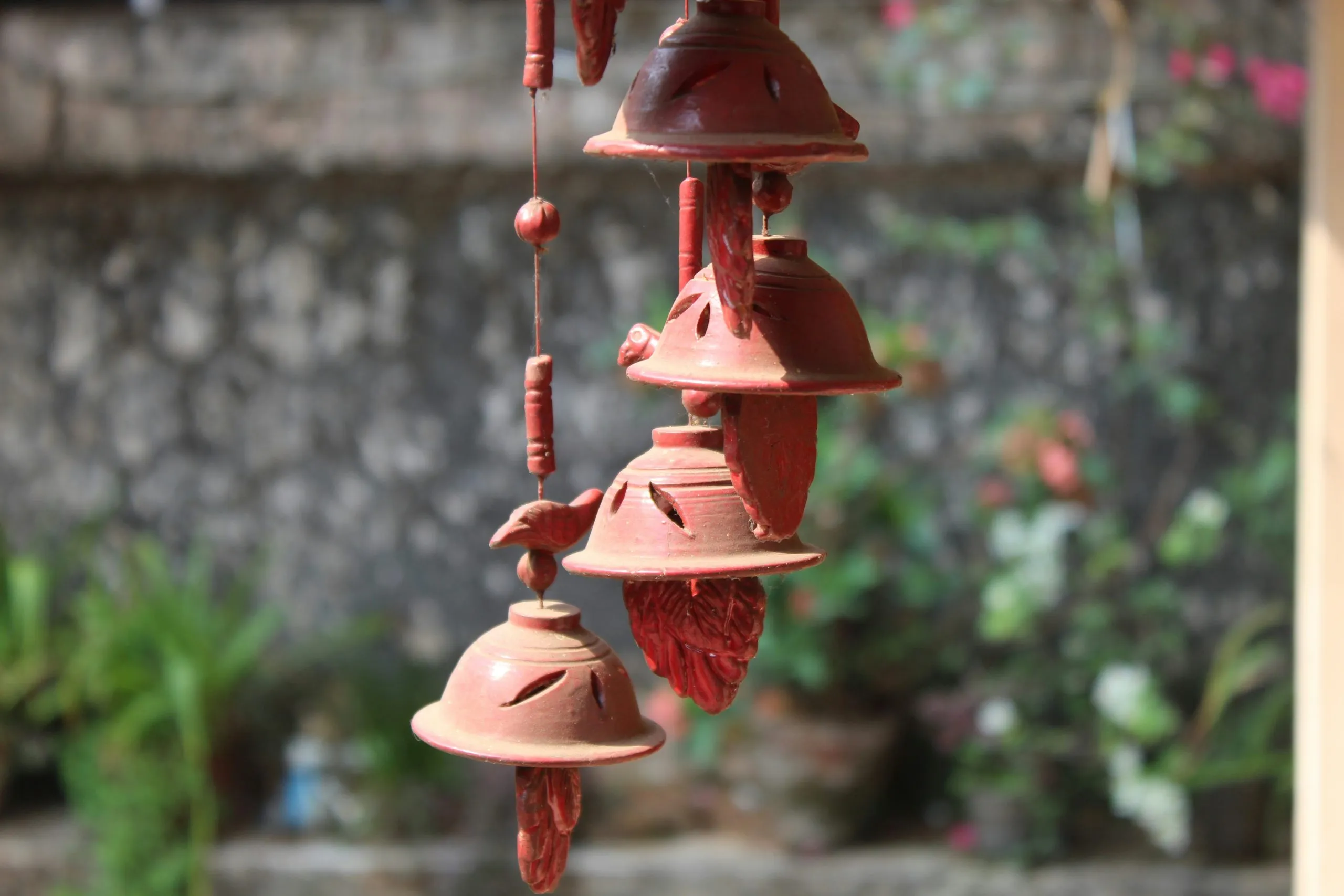 A terracotta windspiel in a garden