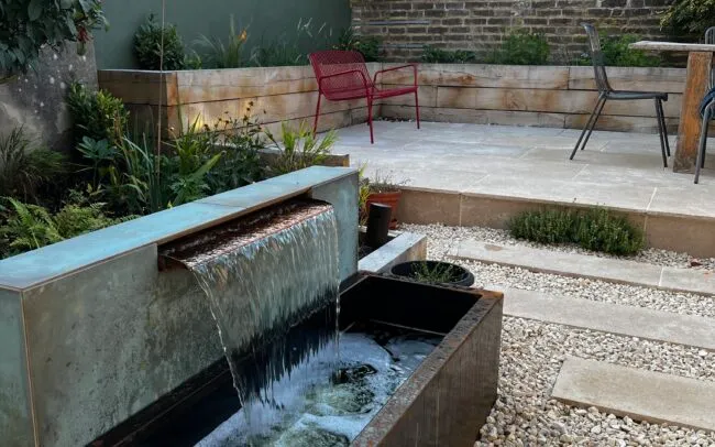 A waterfall trough feature in a garden