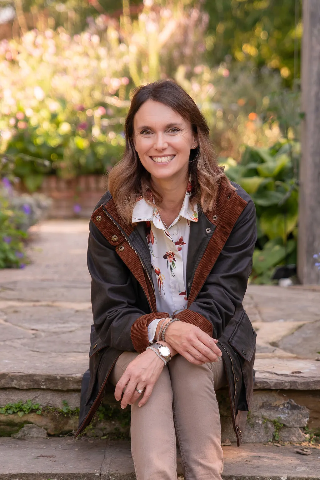 Victoria Rumens sitting on steps to a garden.
